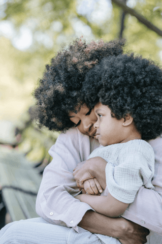 A tender moment between a mother and her child, both with curly hair