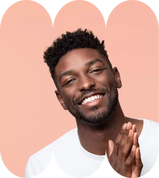 A man with a beard wearing a white shirt, smiling and looking directly at the camera.
