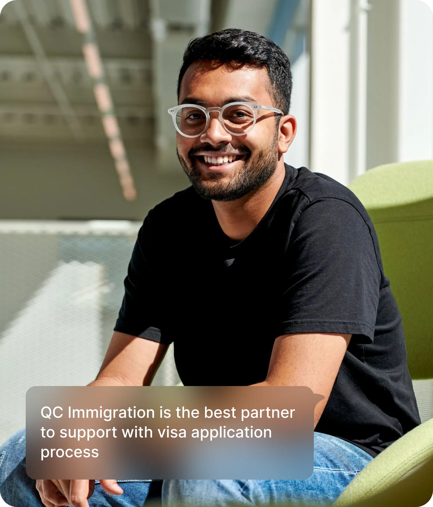 A man in glasses seated on a chair, with text stating "QC Immigration is the best partner for visa application support."